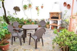 un patio con sillas, mesa y chimenea en El Regocijo, en Oliva de la Frontera