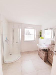 a white bathroom with a shower and a sink at Ferienwohnung Familie Sobierajczyk - Fewo unweit Ostsee in Blankenhagen