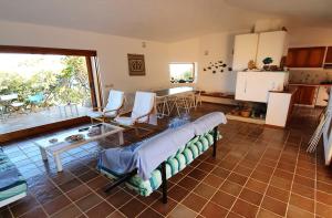 a room with a bed and a table and a kitchen at Villa Tramonti di Gallura 