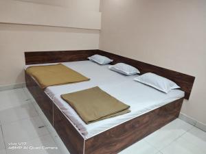 a bed with two pillows on it in a room at Sai Ganesh Guest House in Shirdi