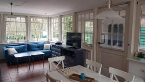 un salon avec un canapé bleu et une télévision dans l'établissement Ferienhaus Astrid Lindgren, à Spiekeroog