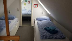 mały pokój z 2 łóżkami i lustrem w obiekcie Ferienhaus Astrid Lindgren w mieście Spiekeroog