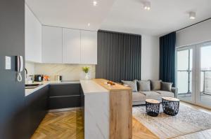 cocina y sala de estar con sofá en SKY Home- Sunset Penthouse -Neopolis, Centrum, Klimatyzacja, Parking Dostęp na Kod en Lodz