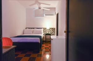 um quarto com uma cama e uma ventoinha de tecto em PH 19 Guesthouse Hotel in Gazcue em Santo Domingo