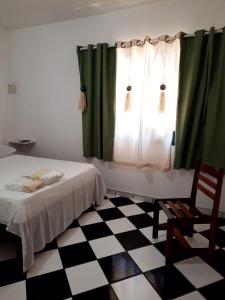 1 dormitorio con 1 cama y una ventana con cortinas verdes en Amarelo Do Morro, en Morro de São Paulo
