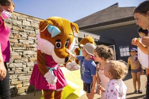 a group of children standing around a mascot at Belambra Clubs Guidel - Les Portes De L'Océan in Guidel-Plage