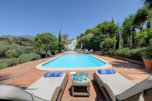 einem Pool mit Liegestühlen und einem Resort in der Unterkunft Molino Cottage in Estepona