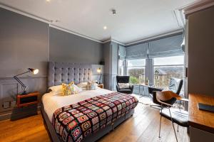 a bedroom with a bed and a desk and chairs at Escape Boutique B&B in Llandudno