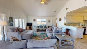 sala de estar amplia con sofás y cocina en LP10 Beach House on Stilts, Ocean View from Back Porch, Boardwalk, Outdoor Shower, en Port Aransas