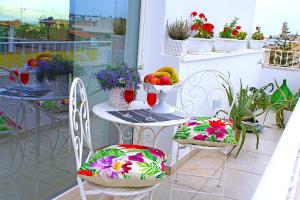 カザラーノにあるB&B WHITEのバルコニー(花と果物付)にテーブルと椅子を用意しています。