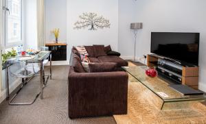a living room with a couch and a tv at Jay's Apartment Aberdeen in Aberdeen