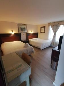 um quarto de hotel com duas camas e uma secretária em Hotel Cantamar em Viña del Mar