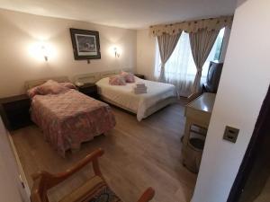 a hotel room with two beds and a television at Hotel Cantamar in Viña del Mar +9 photos