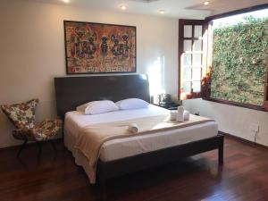 a bedroom with a large bed and a chair at Casa da 17 - Lago Sul in Brasilia