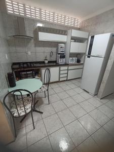 uma cozinha com uma mesa e um frigorífico em Sua casa fora de casa em Fortaleza