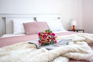 a book with a bouquet of flowers on a bed at Villa Dika Nin in Nin