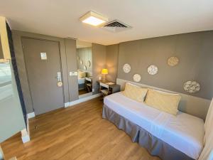 a bedroom with a white bed and a room with a bed sqor at Magna Praia Hotel in Fortaleza