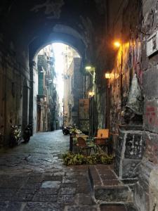 een steegje met een boog in een stad 's nachts bij Napolicentrico in Napels