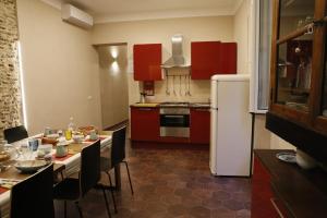 een keuken met rode kasten en een tafel met stoelen bij Napolicentrico in Napels