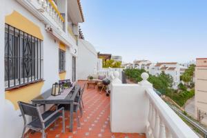 a balcony with tables and chairs on a building at Villa Mar del Plata 8 bed apartment in Fuengirola