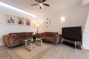 a living room with couches and a flat screen tv at Villa Mar del Plata 8 bed apartment in Fuengirola