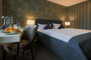 una habitación de hotel con una cama y una mesa con un bol de fruta en Landhotel Zum Kronprinzen, en Oberwesel