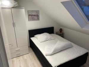 ein kleines Schlafzimmer mit einem Bett mit weißer Bettwäsche in der Unterkunft Appartement in Olpe