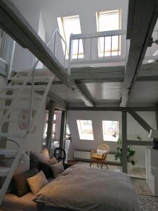 a loft bedroom with a bed and a ladder at Loft "im Alten Pfarrhaus" in Neuruppin