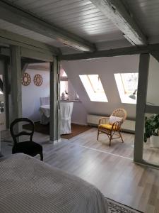 een slaapkamer met dakramen en een bed en stoelen bij Loft "im Alten Pfarrhaus" in Neuruppin