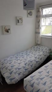 a bedroom with two beds and a window at Sunrise 77 Sandown Bay Holiday Centre Generous Ferry Saving! in Sandown