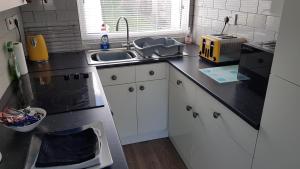 a kitchen with a sink and a counter top at Sunrise 77 Sandown Bay Holiday Centre Generous Ferry Saving! in Sandown