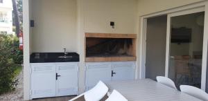 a white kitchen with a table and a sink at Garden View 2 Dormitorios con Jardín y Parrillero hasta 7 personas in Punta del Este