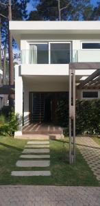 a white house with a walkway in front of it at Garden View 2 Dormitorios con Jardín y Parrillero hasta 7 personas in Punta del Este