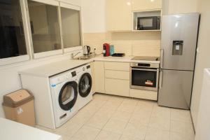 eine Küche mit einem Kühlschrank und einer Waschmaschine in der Unterkunft New : Grand T4 Cosy et tout équipé in Créteil