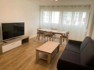 ein Wohnzimmer mit einem Tisch, einem Sofa und einem TV in der Unterkunft New : Grand T4 Cosy et tout équipé in Créteil