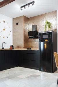 kuchnia z czarnymi urządzeniami i czarną lodówką w obiekcie Requena Suite Apartment w Sewilli