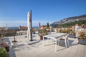 a patio with a table and chairs and an umbrella at LA ROCCA SUITE in Garda