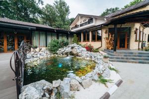 a koi pond in front of a house at Popas Dumbravita in Răstoaca