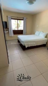 a bedroom with a bed and a window and a tiled floor at Chalé com piscina privada vista mar-Zumbi-RN in Rio do Fogo +32 photos