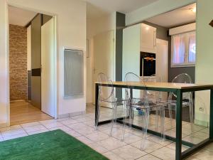 - une cuisine avec une table à manger et des chaises dans l'établissement Blagnac : appartement T2 avec jardin, parking et climatisation, à Blagnac