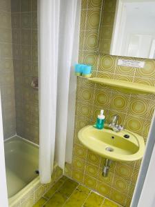 ein Badezimmer mit einem gelben Waschbecken und einer Badewanne in der Unterkunft Die Schlafstube in Neuharlingersiel