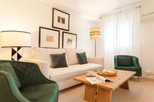 Sala de estar con sofá, 2 sillas y mesa de centro en Genteel Home Velarde, en Sevilla