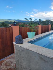 a backyard with a swimming pool and a wooden fence at Royal Vybez Vacation Homes in Spanish Town