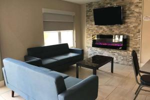 a living room with a couch and a tv at Baymont by Wyndham Lake Park Valdosta I75 in Lake Park