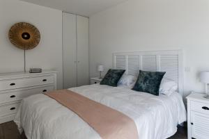 a white bedroom with a large bed with two pillows at Superbe appartement neuf face plage sur l ile de Noirmoutier in La Guérinière