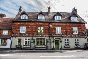 a large brick building on the corner of a street at The Swan Inn in Chiddingfold