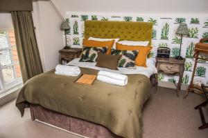 a bedroom with a bed with towels on it at The Swan Inn in Chiddingfold