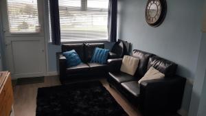 a living room with two leather chairs and a couch at Sunrise 77 Sandown Bay Holiday Centre Generous Ferry Saving! in Sandown