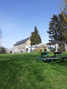 a picnic table in a field with a gazebo at Le Bonheur En Bretagne in Rouillac