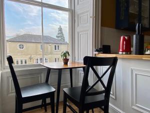 a table and two chairs in a kitchen with a window at The Georgian Manor Apartment - Central Frome in Frome
